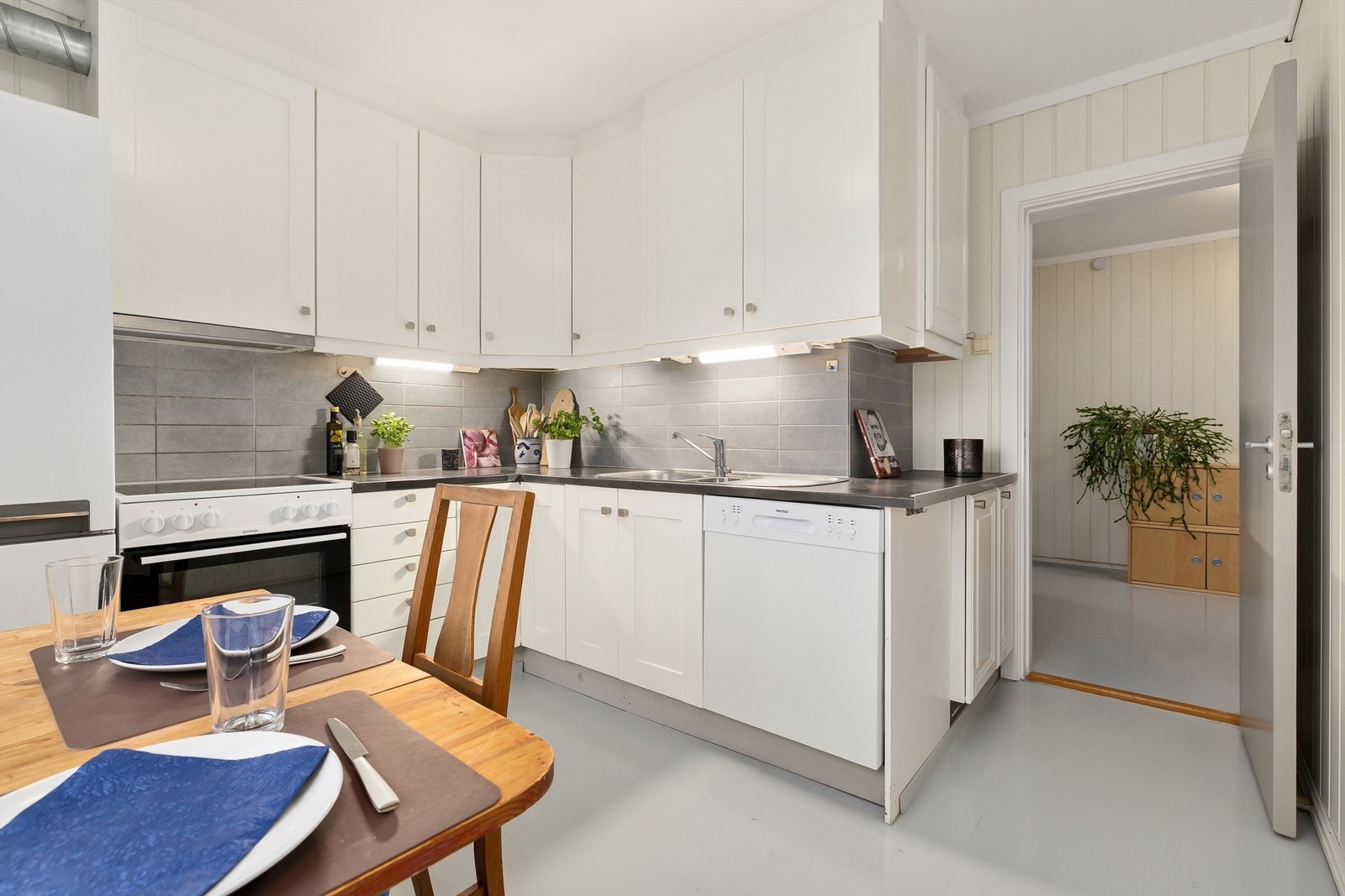 Lyst kjøkken med plass til frokostbord. Galleribilde