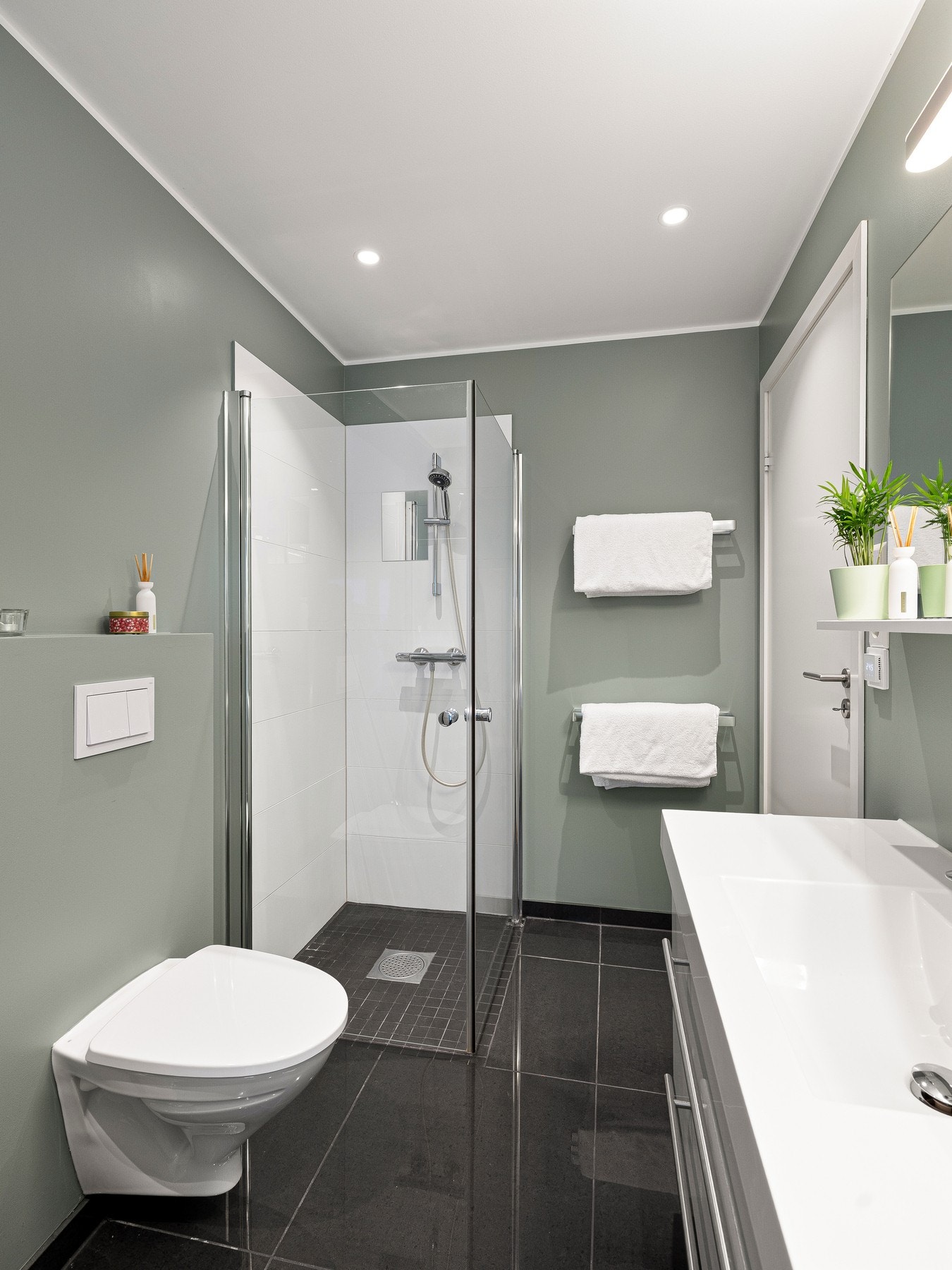 Videre har badet opplegg for vaskemaskin/tørketrommel, dusjhjørne med innfellbare glassdører, downlights og varmekabler. Galleribilde