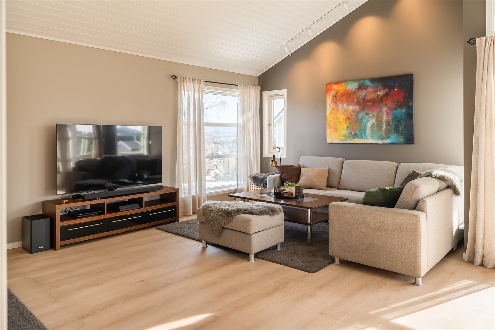 Et skjermet sofahjørne med god plass til en romslig sofagruppe og egen TV-sone. Galleribilde