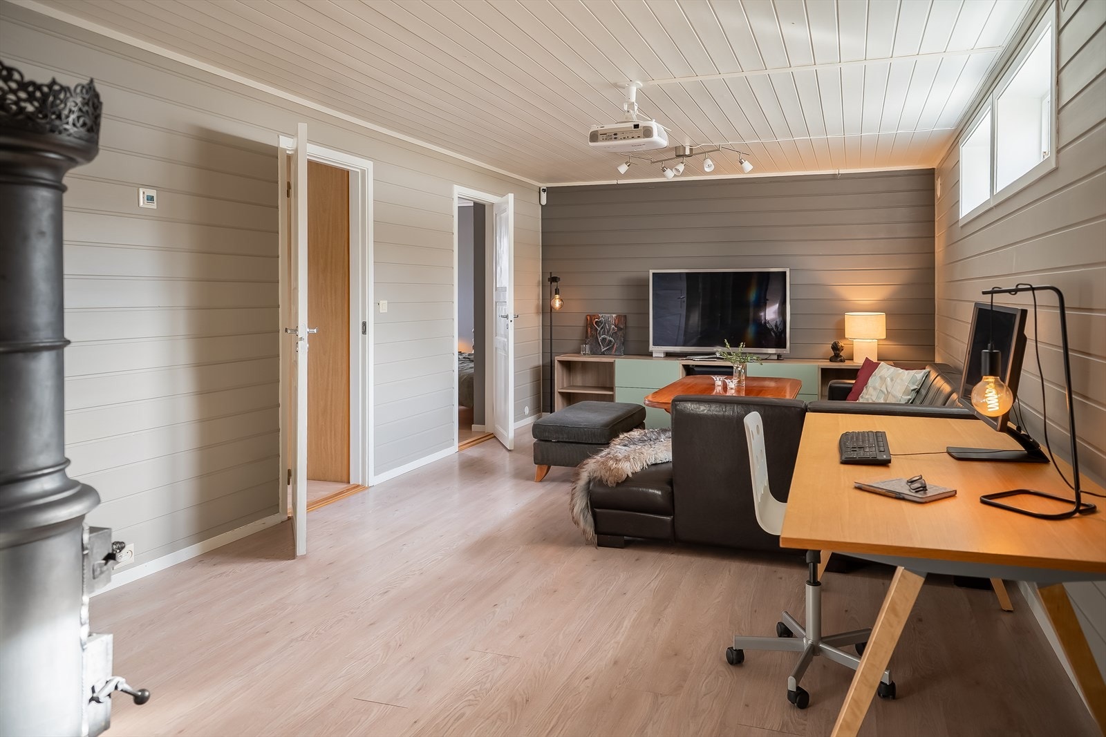 Den romslige kjellerstuen på 36,2 m² er i dag innredet med sofakrok og hjemmekontor, og byr på gode bruksmuligheter. Galleribilde