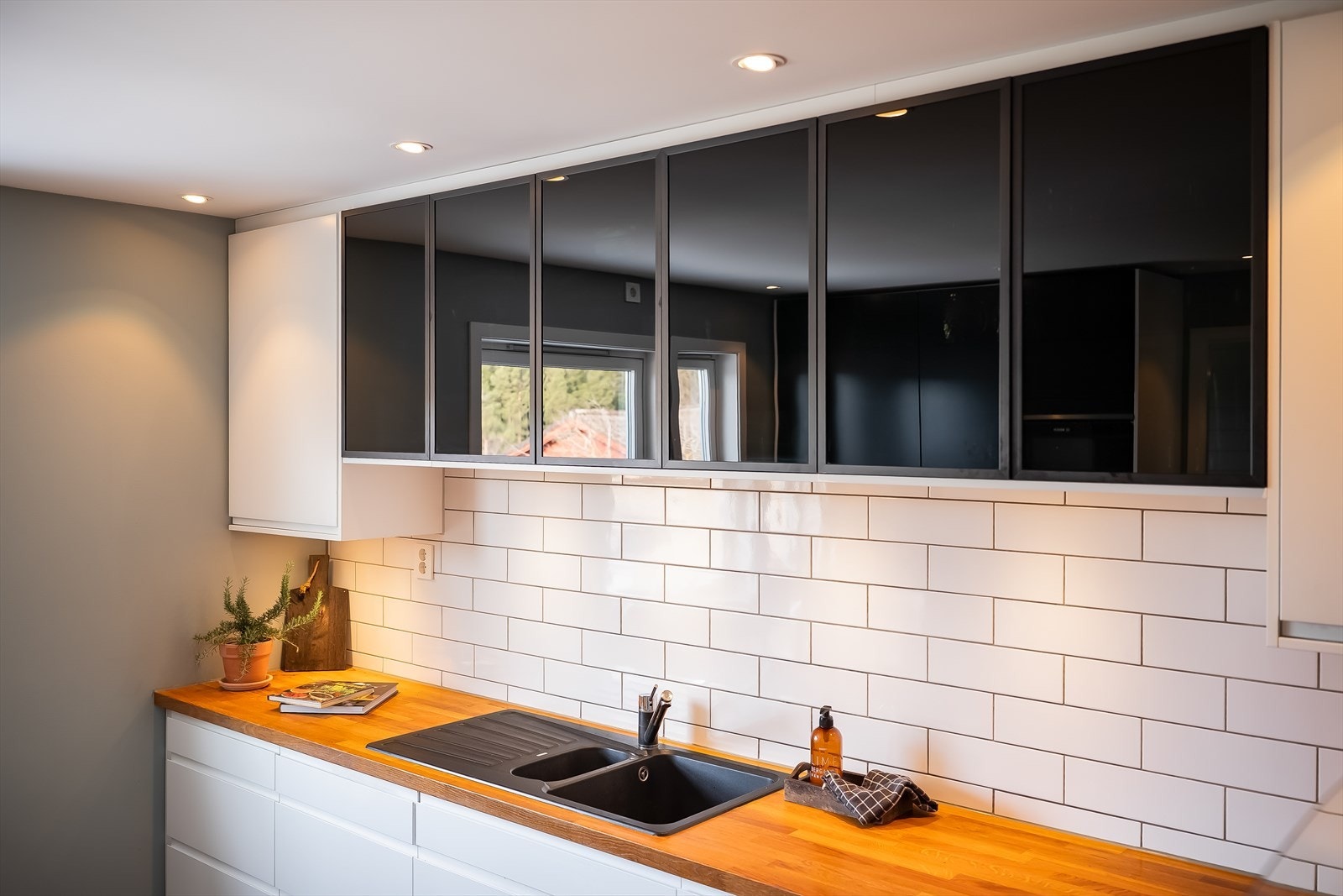 Kjøkkenet har en stilren, flislagt backsplash som både beskytter veggen og bidrar til et helhetlig uttrykk. Galleribilde