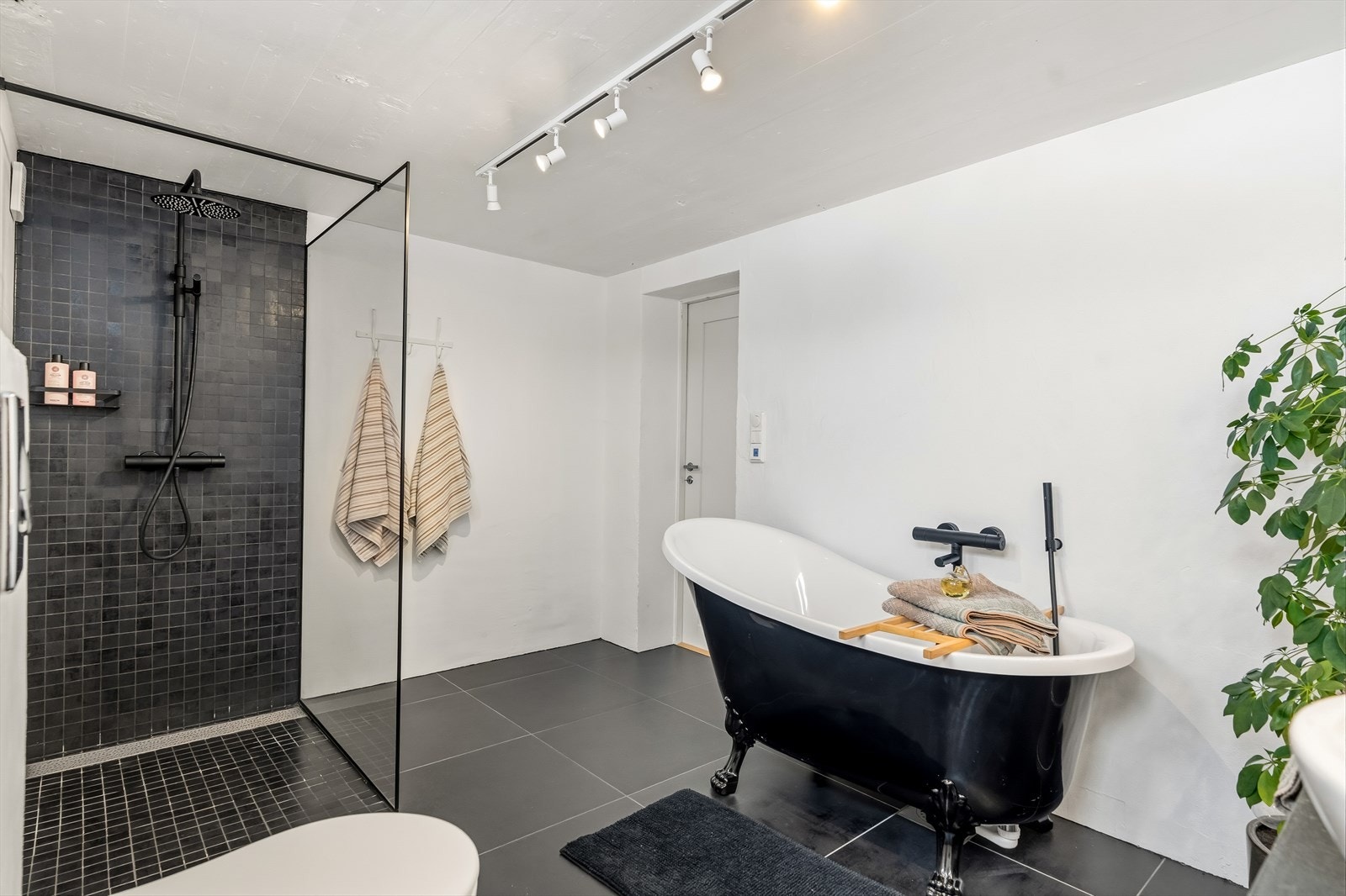 Varme er lagt i gulvet, og badet har vegghengt toalett, en moderne skuffeløsning med toppmontert servantskål og et matchende speilskap med god belysning. Galleribilde