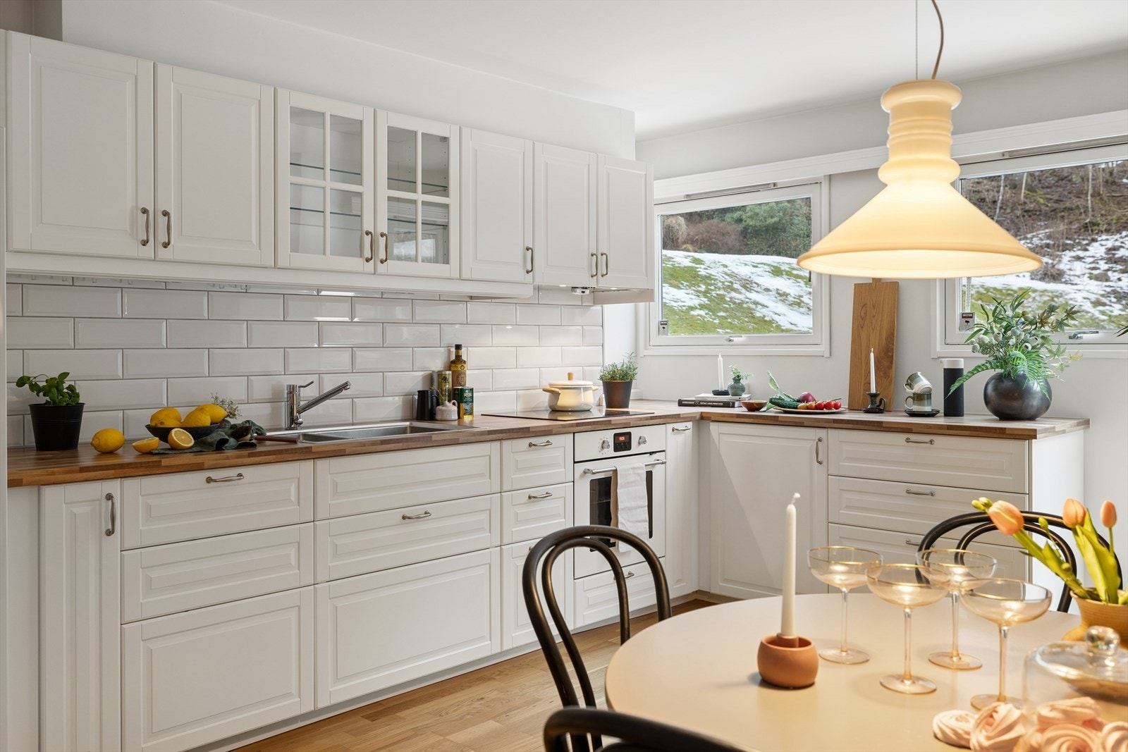 Kjøkkenet har innredning fra IKEA med profilerte lakkerte fronter, laminat benkeplate og fliser på bakvegg Galleribilde