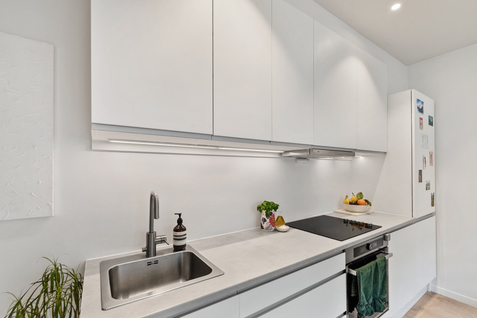 Her er hver kvadratmeter utnyttet maksimalt med godt med lagringsplass i over- og underskap. Integrerte hvitevarer gir et tidløst og pent inntrykk. Galleribilde