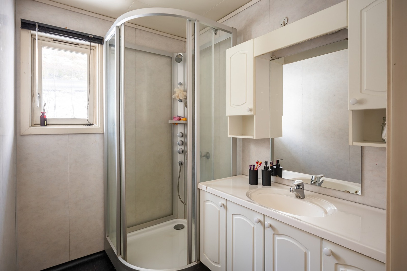 Badet har dusjkabinett og servant med innredning. Galleribilde