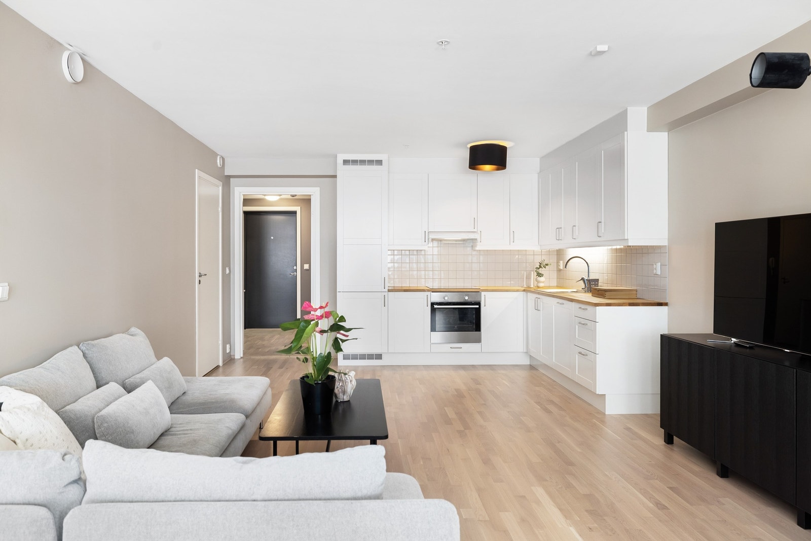 Kjøkkeninnredning med profilerte fronter, benkeplate i tre, fliser mellom benkeplate og overskap. Galleribilde