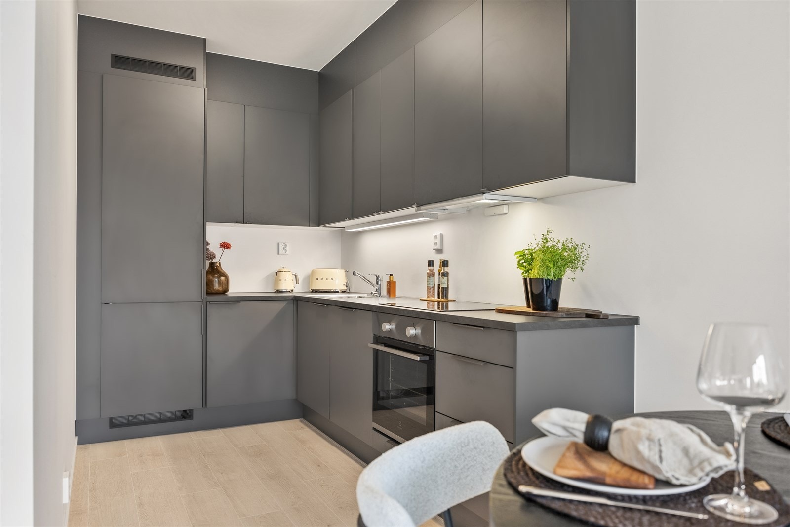 Kjøkkenet er velutstyrt med integrerte hvitevarer som kombiskap, komfyr, platetopp og oppvaskmaskin. Galleribilde