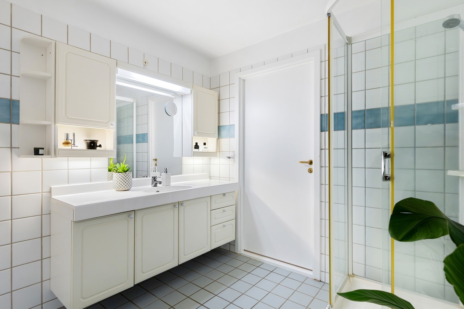 Romslig, flislagt baderom med gulvvarme og opplegg for vaskemaskin. Galleribilde