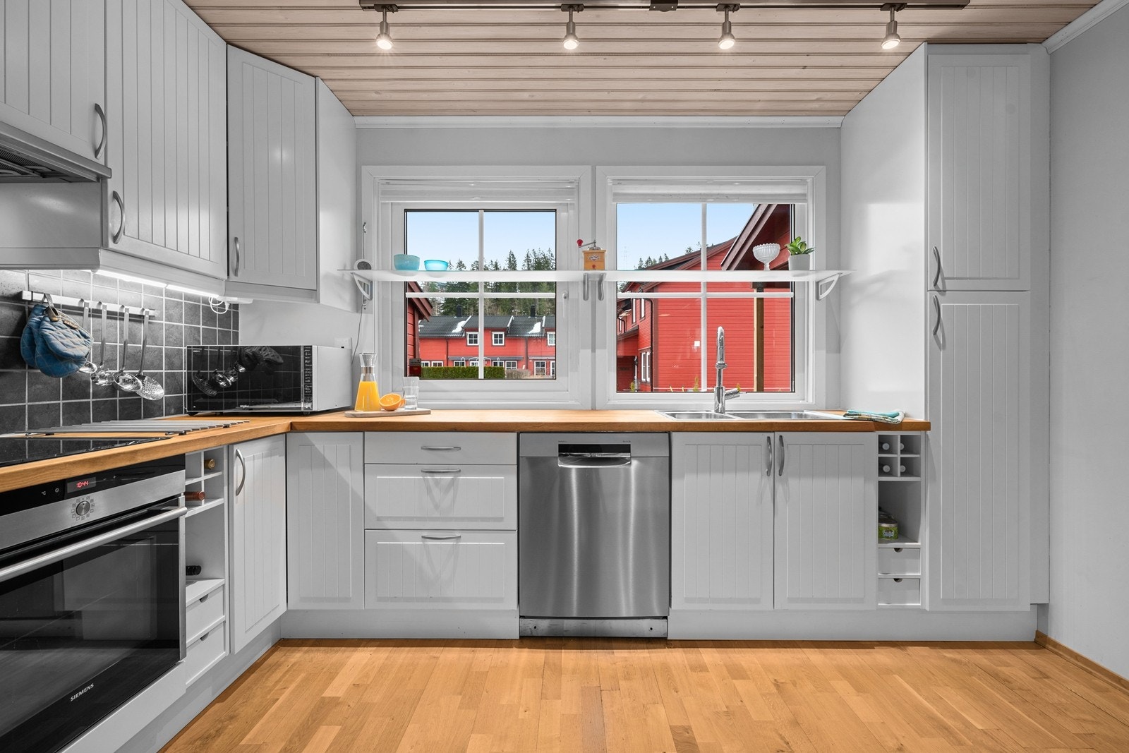 Kjøkkenet er utstyrt med rikelig skapplass og smarte oppbevaringsløsninger, inkludert vinhyller. Galleribilde