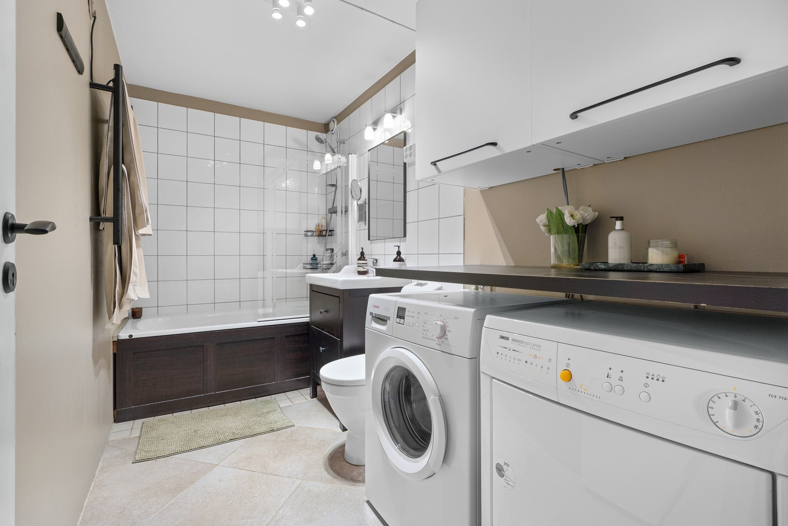 Bad med badekar, god oppbevaringsplass og opplegg for både vaskemaskin og tørketrommel Galleribilde