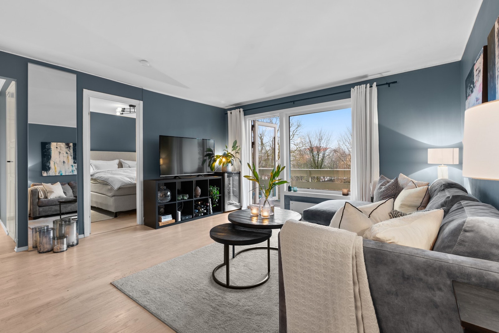 Det er store vindusflater i enden av stuen som gir rommet fine lysforhold Galleribilde