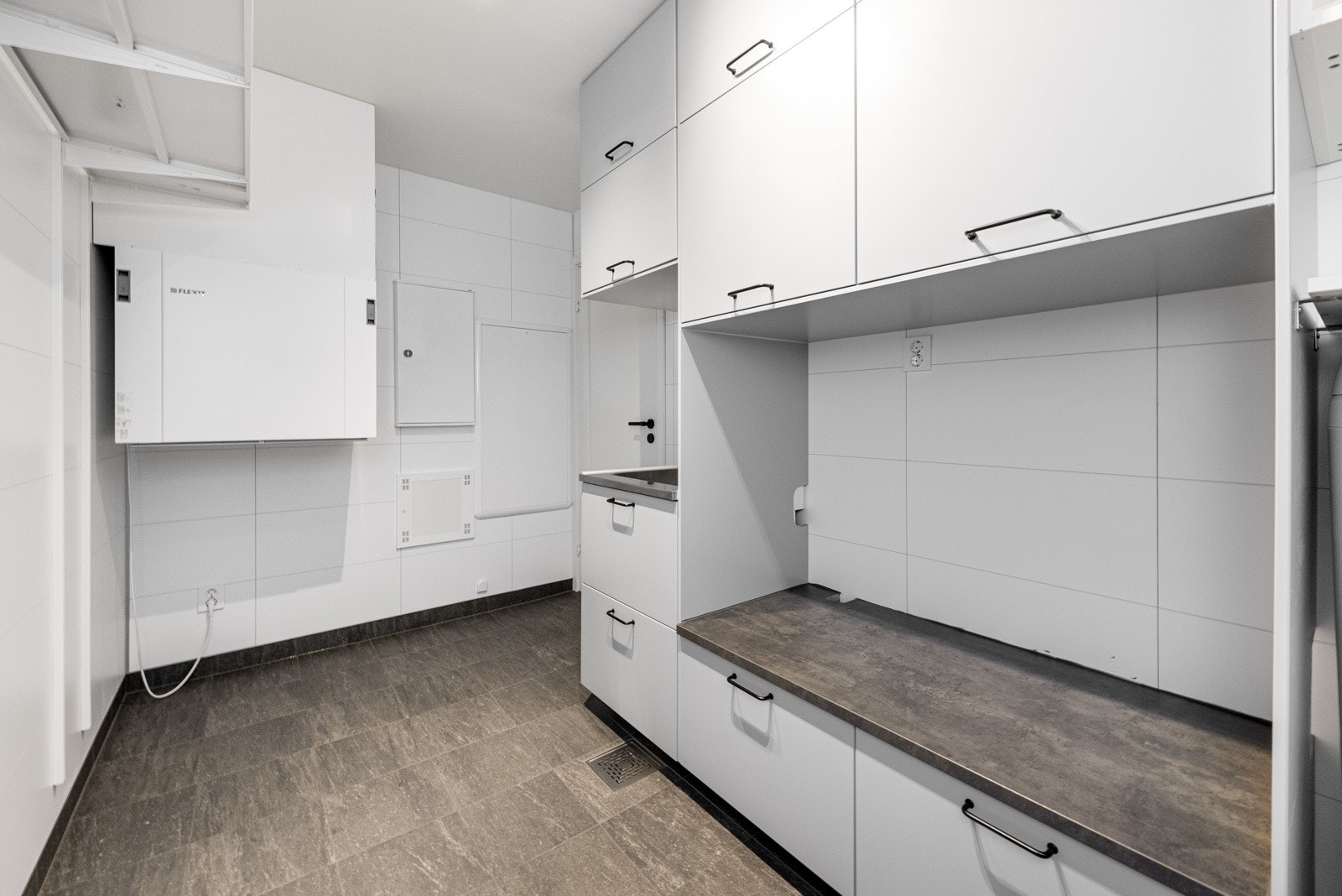 Opphøyet plass for vaskemaskin og tørketrommel i egen nisje. Varmtvannbereder er på ca. 200 liter. Galleribilde