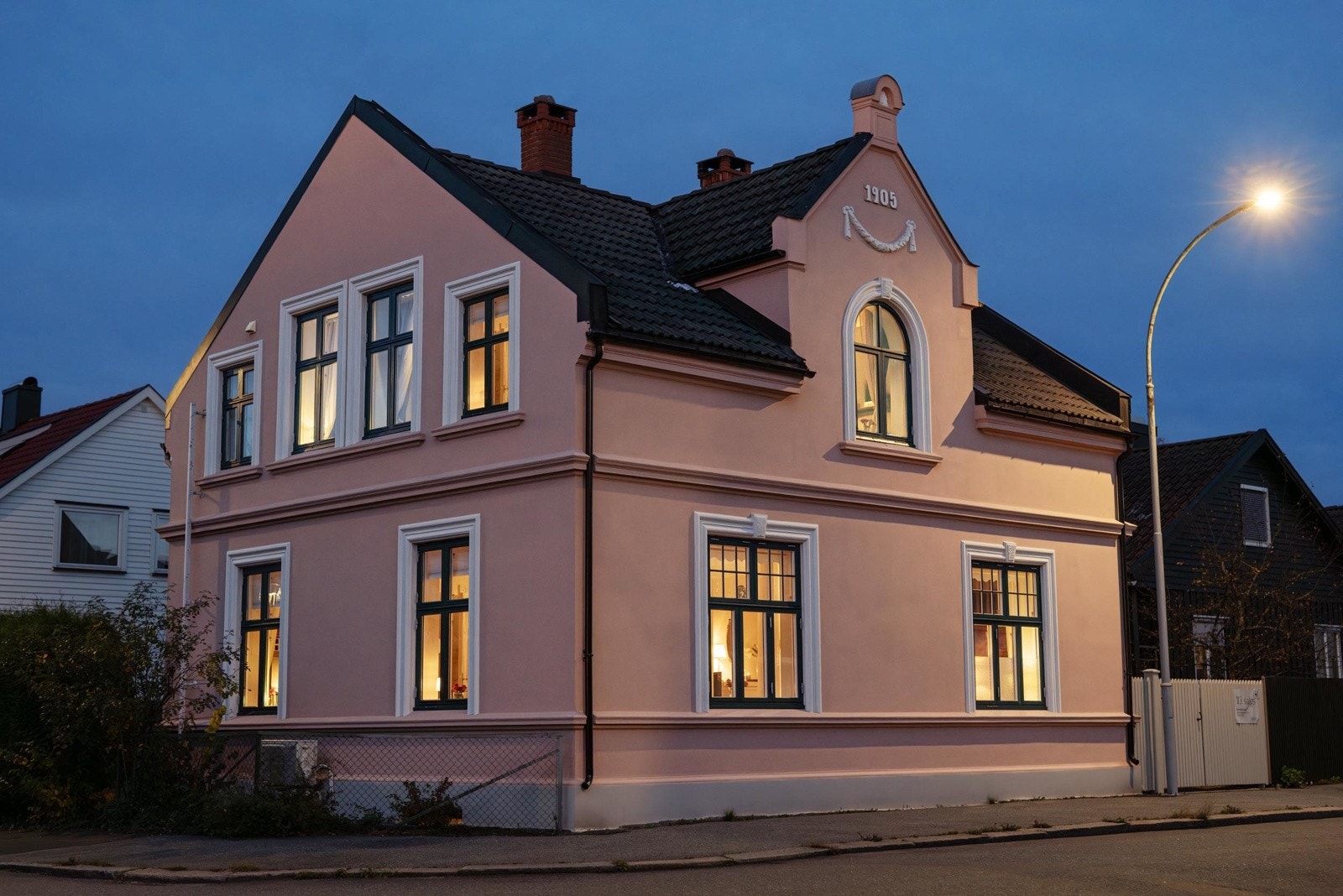 Den varme rosatonen med kontrastfargede vindusrammer og mørkt tak gir et elegant, kontinentalpreg. Galleribilde