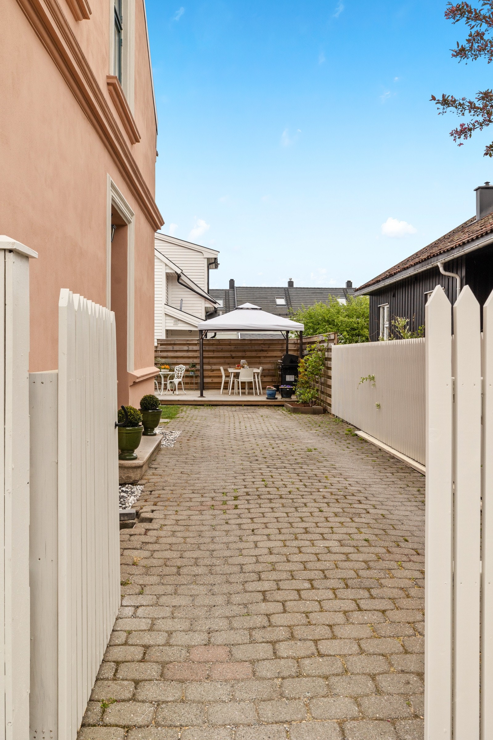 Velkommen inn i bakgården! Dobbel port som skjermer for innsyn. Stenlagt gårdsplass. Galleribilde