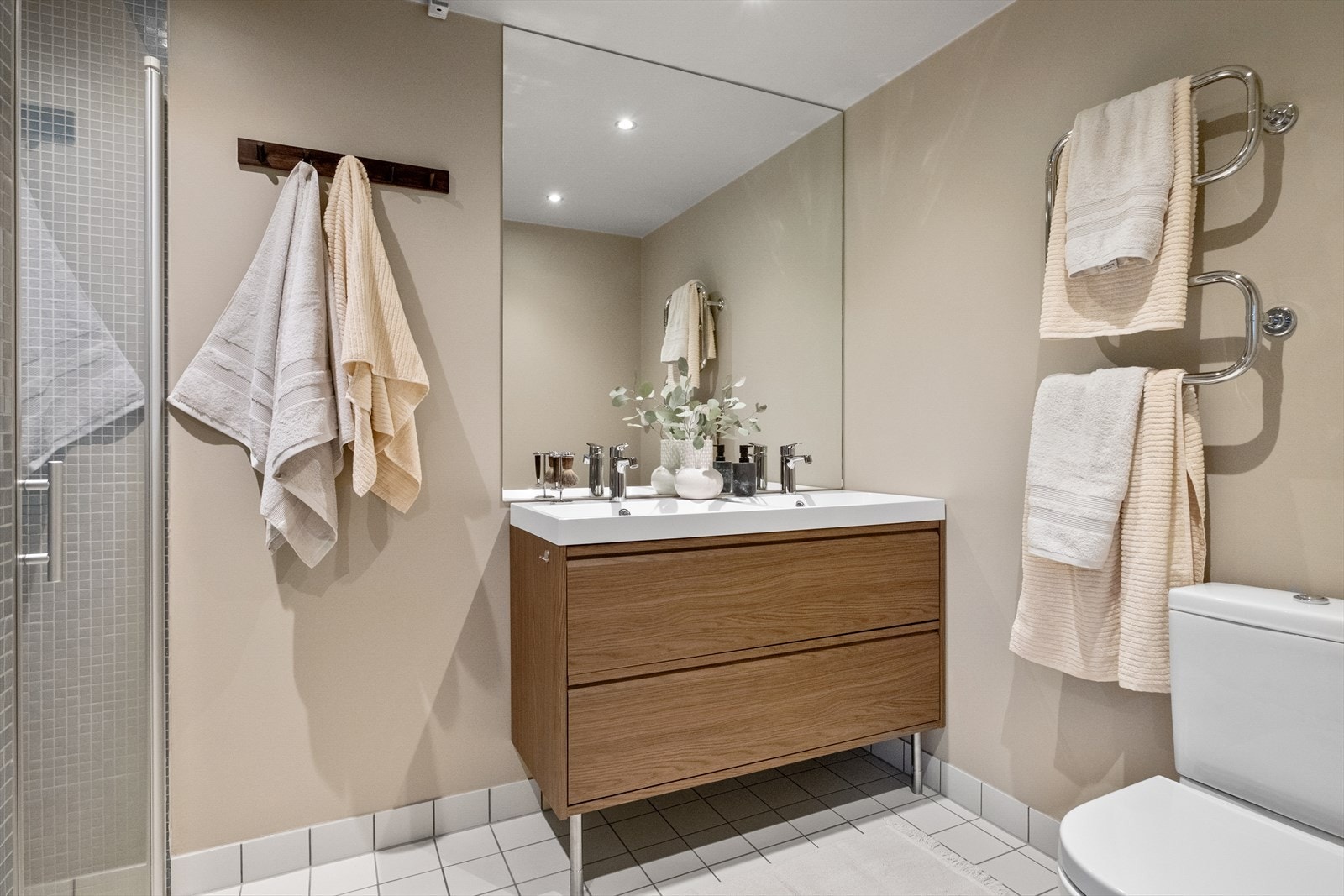 Pent og romslig bad fra 2011. Her er det flislagt gulv med elektriske varmekabler, og stilige mosaikkfliser i dusjsonen. Galleribilde