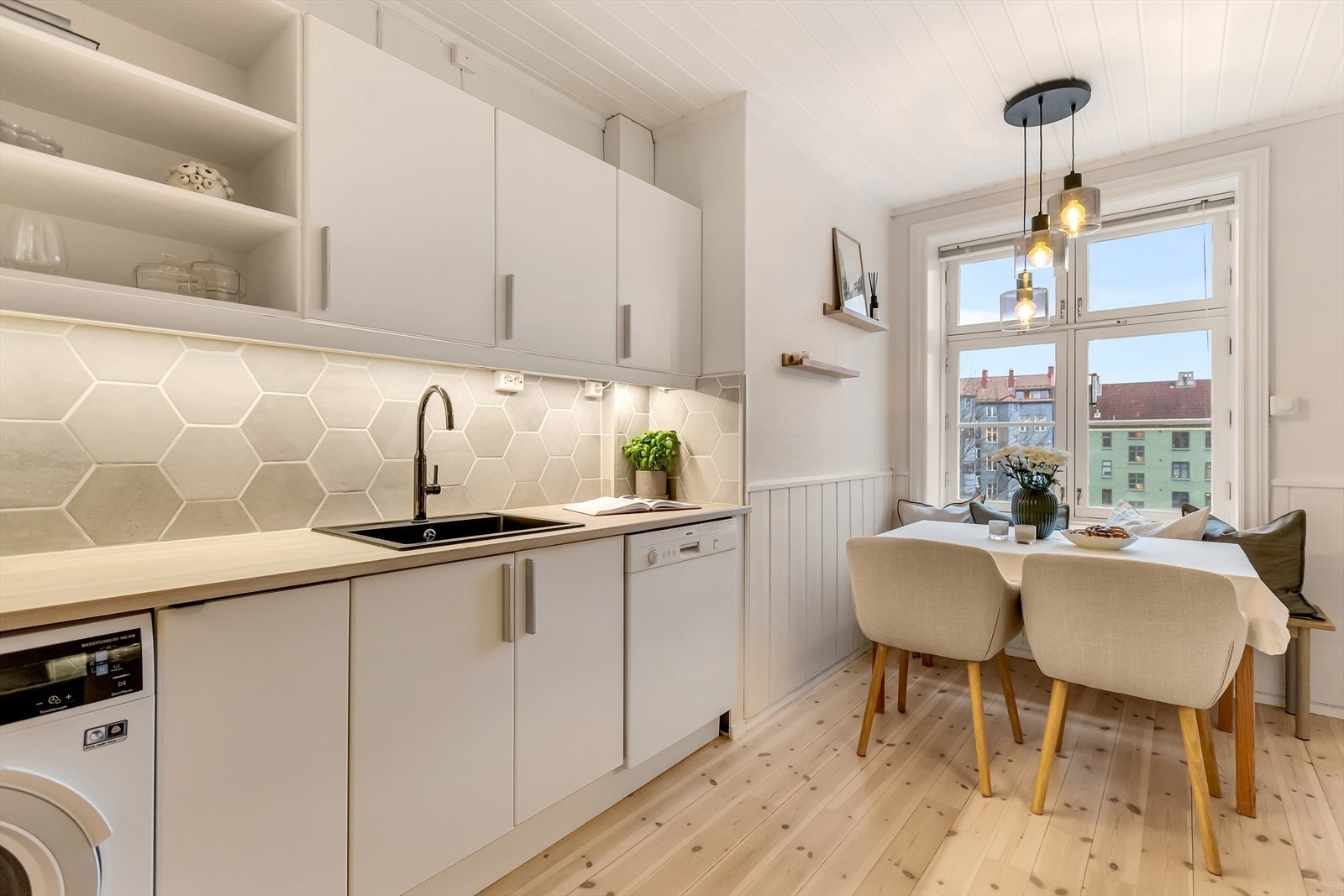 Lyst og pent kjøkken med glatt, laminert kjøkkeninnredning og heltre benkeplate som gir et varmt preg. Galleribilde