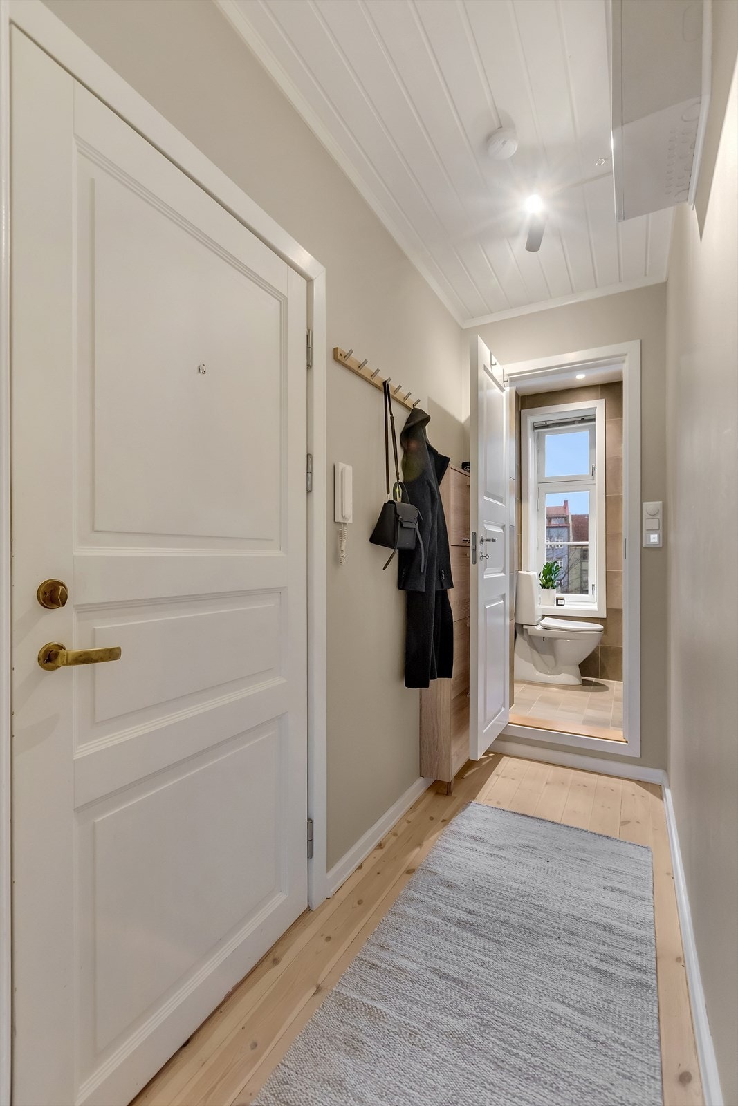 Velkommen inn! Entréen er lys og innbydende med lyse overflater og tregulv som gir et hyggelig førsteinntrykk av boligen. Galleribilde