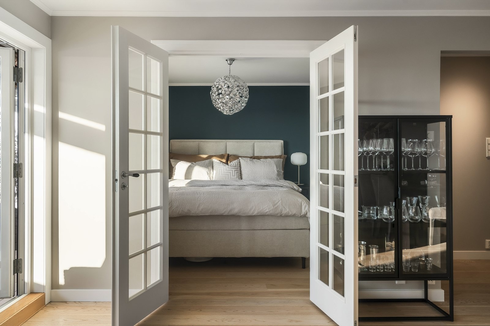 Romslig soverom adskilt fra stuen med tofløyet glassdør. Galleribilde