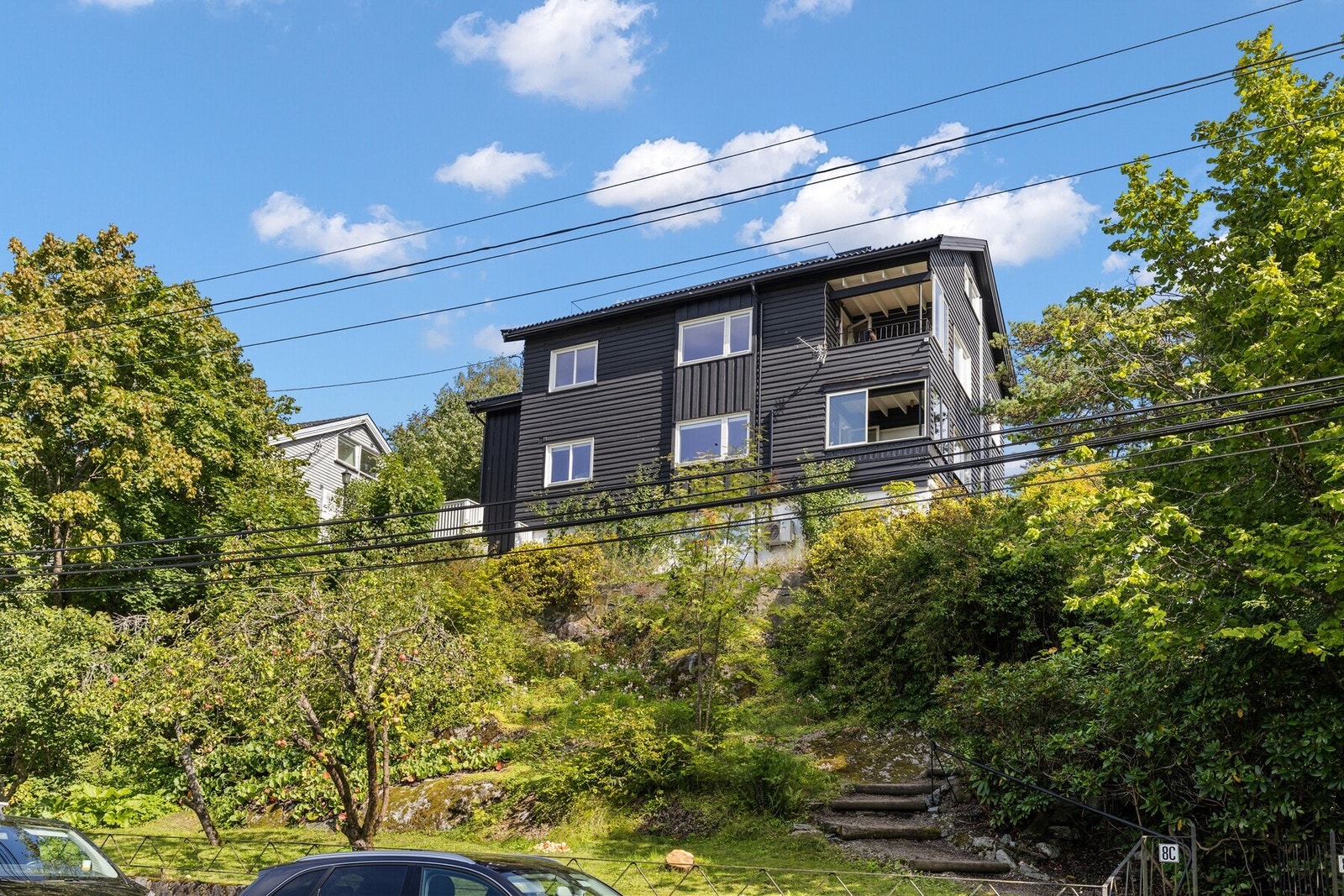 Boligen har en flott beliggenhet på en høyde. Bildet er tatt fra Rosendalsveien (vestsiden av boligen) i sommer før verandaene ble bygget. Galleribilde