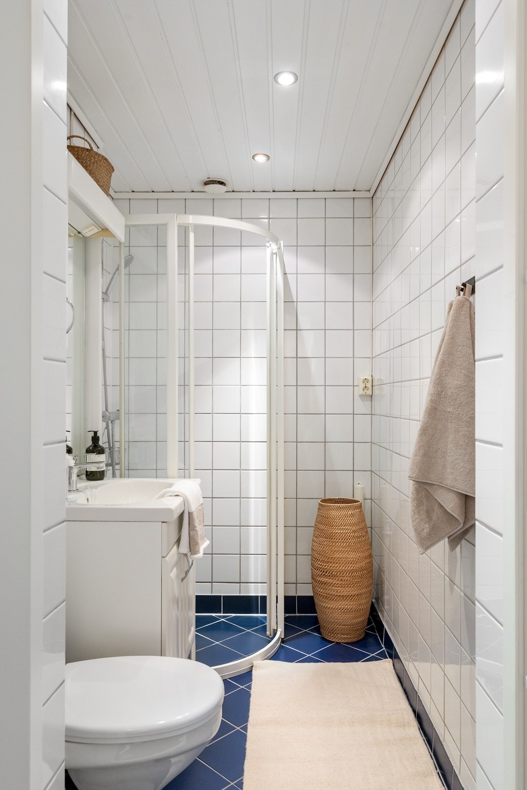 Baderommet er innredet med gulvmontert toalett med utvendig sisterne, baderomsinnredning med profilerte folierte fronter og heldekkende servant. Galleribilde