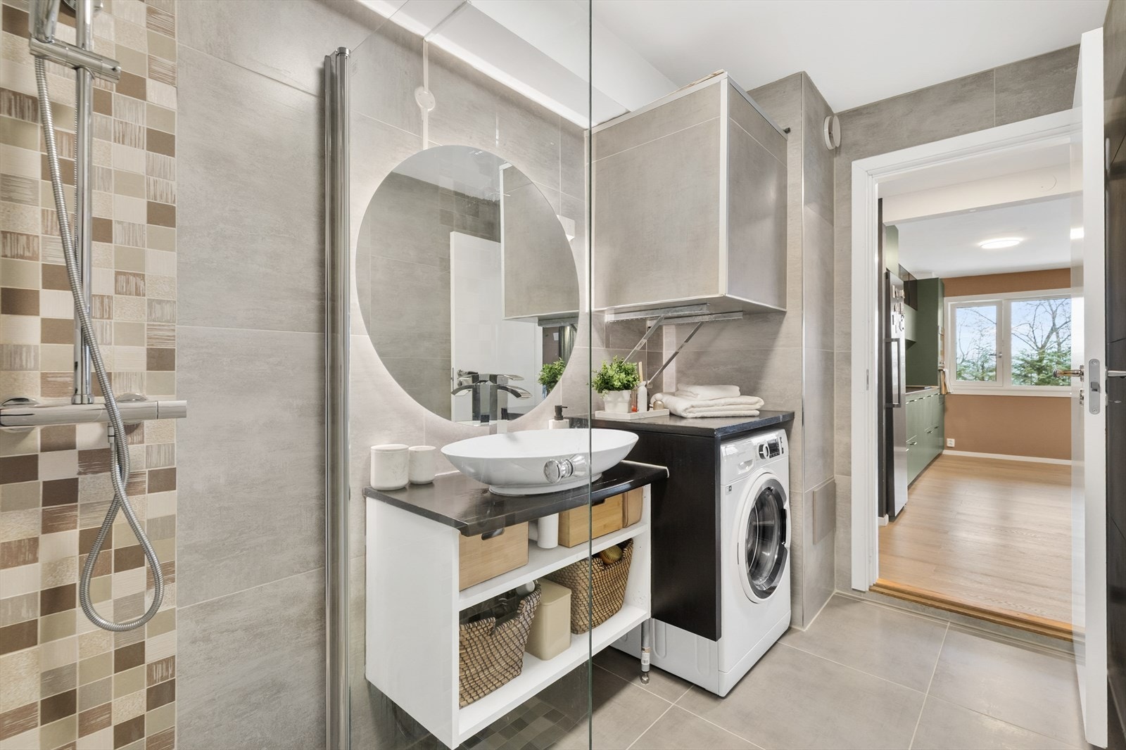 Hovedbadet er helfliset og praktisk innredet med dusjhjørne og opplegg for vaskemaskin. Galleribilde