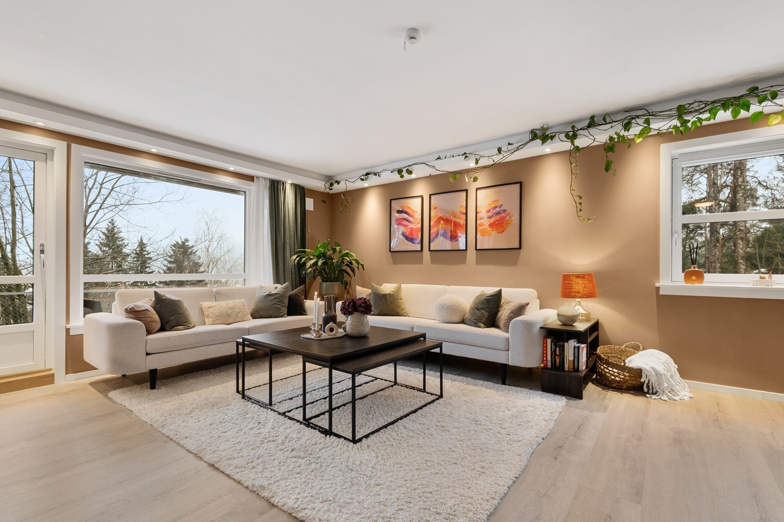 Stuen er en del av den åpne løsningen, med god plass til en romslig sofagruppe og store vindusflater mot naturen. Galleribilde