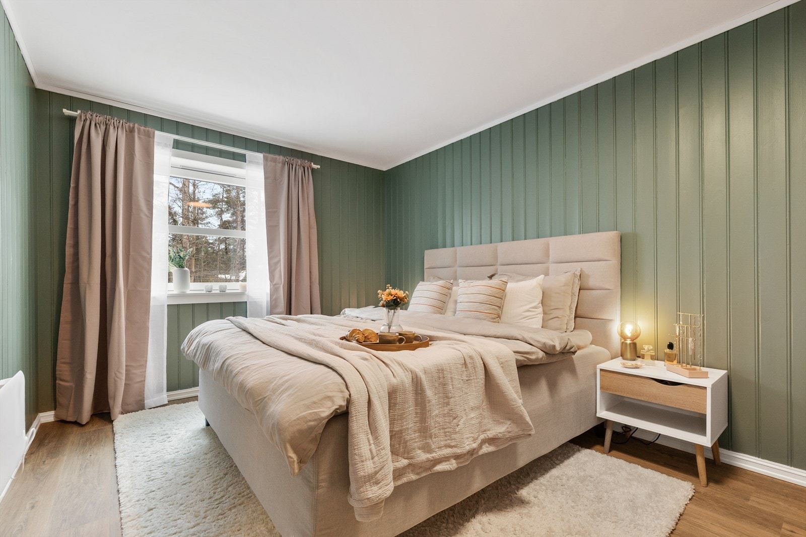 Rommet har god plass til en dobbeltseng og tilhørende nattbord, med en lun vegg i panel. Galleribilde