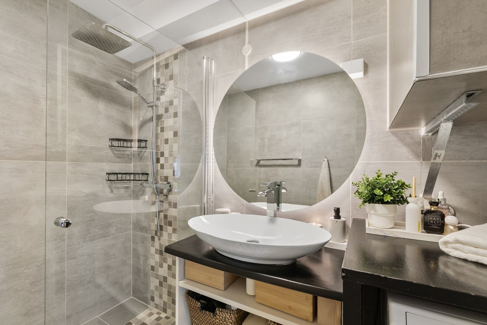 Rommet har elektriske varmekabler i gulvet, dusjhjørne med innfellbare vegger, servantinnredning og opplegg for vaskemaskin. Dusjsonen har en kombinasjon av regnfallsdusj og hånddusj for økt komfort. Galleribilde