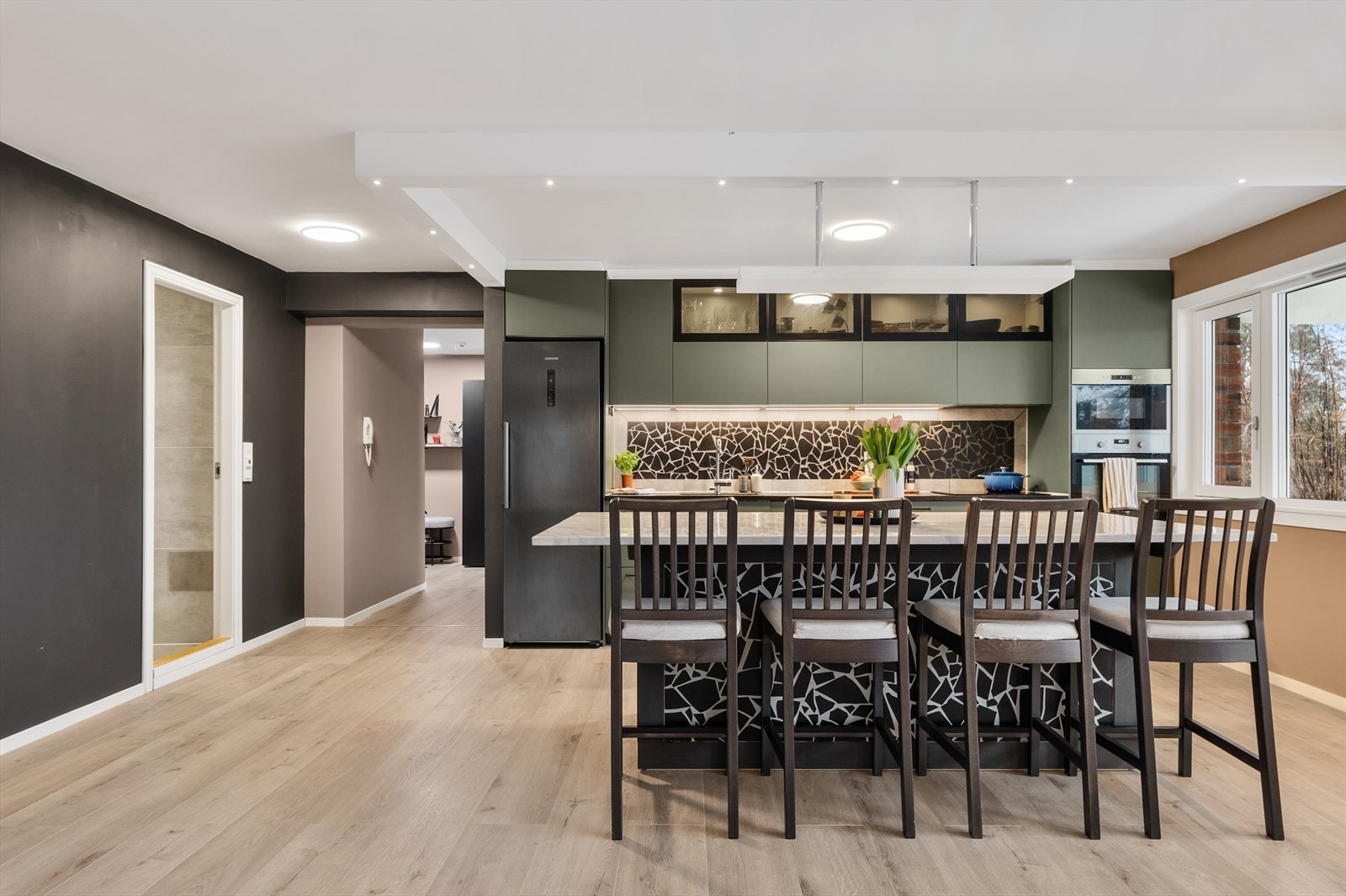 Godt med skap- og benkeplass, kombinert med vitrineskap med belysning, gjør kjøkkenet både funksjonelt og stilfullt. Galleribilde