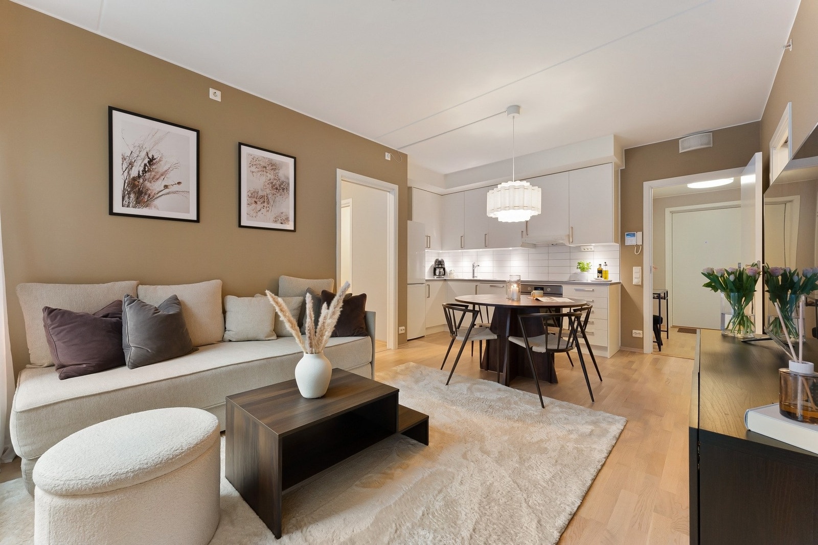 Stor og åpen stue-/kjøkken løsning med naturlige møbleringssoner. Galleribilde