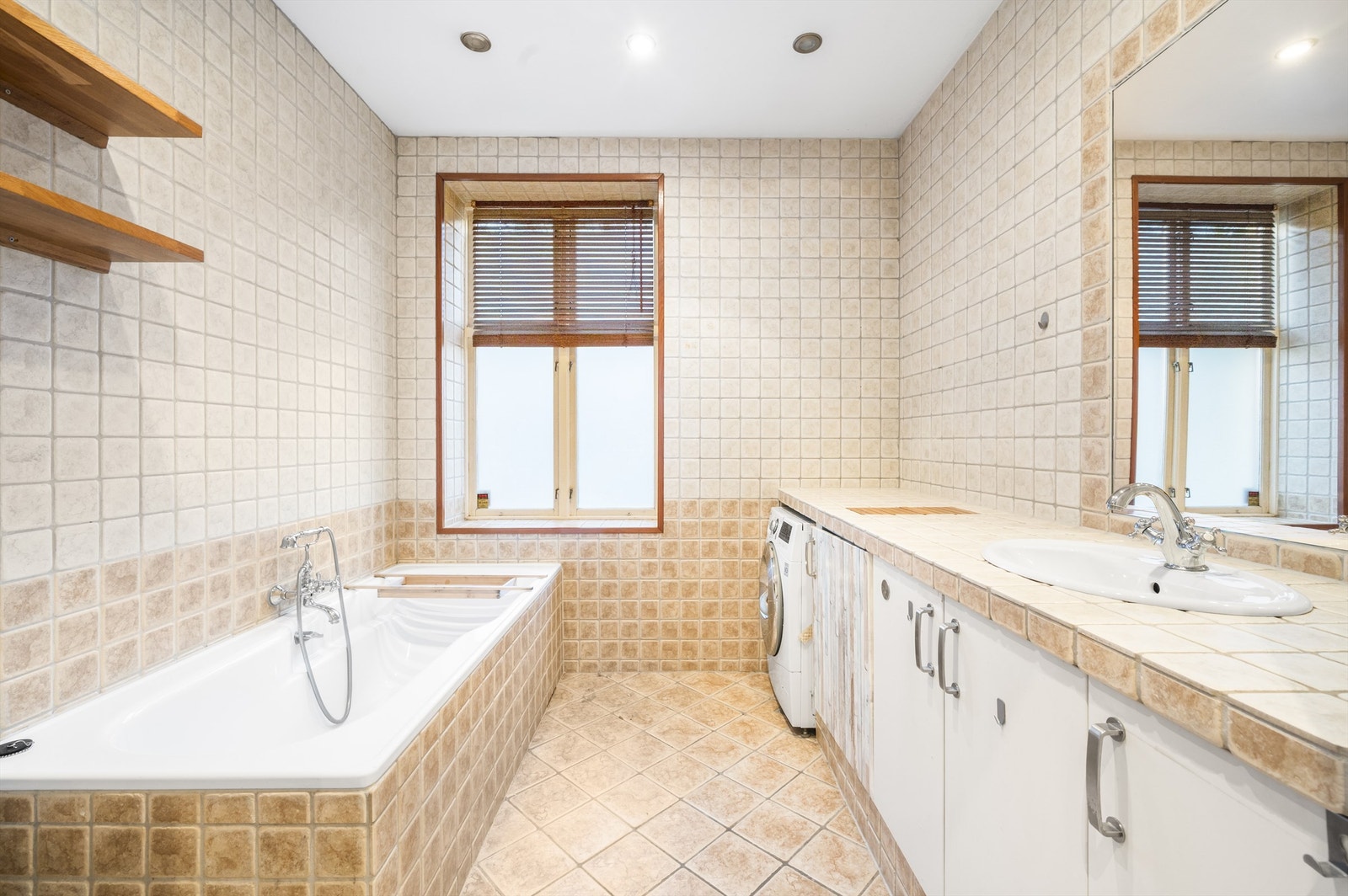 Dette badet ligger innenfor garderoben til hovedsoverommet og fungerer som et privat bad. Badet er romslig og utstyrt med badekar, servant nedfelt i benkeplate og opplegg for vaskemaskin. Galleribilde