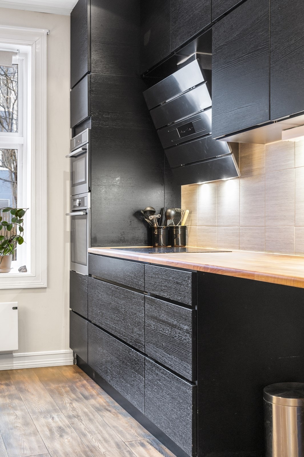 Kjøkkenet har integrert induksjonstopp med avtrekksvifte over kokesonen. Galleribilde