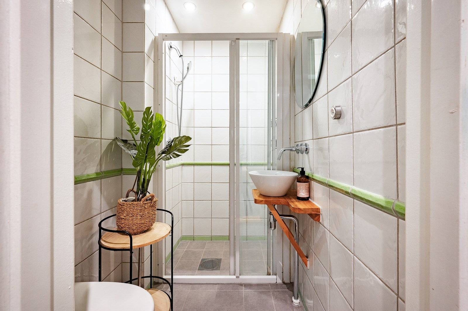 Badet har vegghengt klosett og en servant plassert på en hylleløsning. Galleribilde