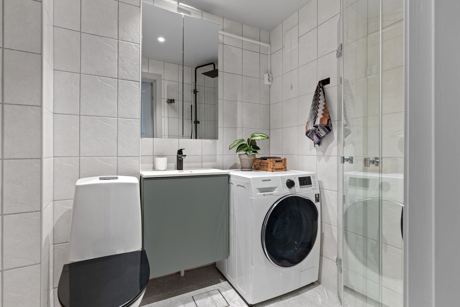 Lekkert tidsriktig flislagt baderom med sjarmerende detaljer og praktiske løsninger. Galleribilde