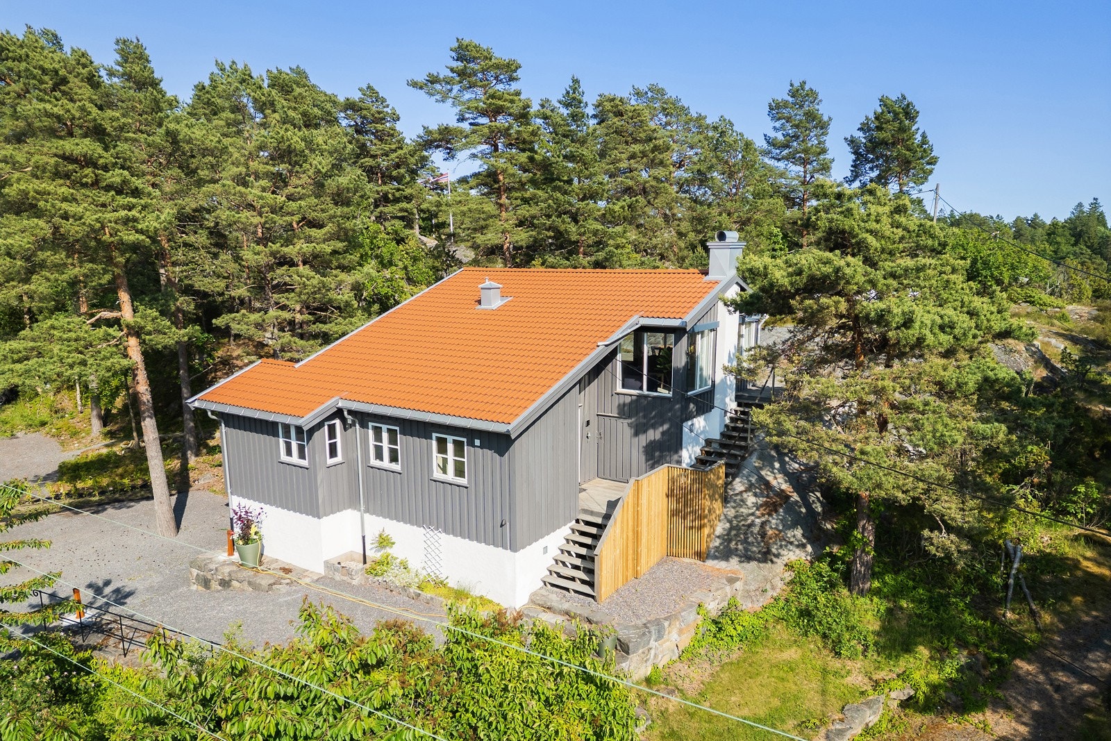 På baksiden er det biladkomst, parkeringsplass og mulighet for å nyte den helt sene kveldssolen. Det er også en liten gressplen der. Galleribilde