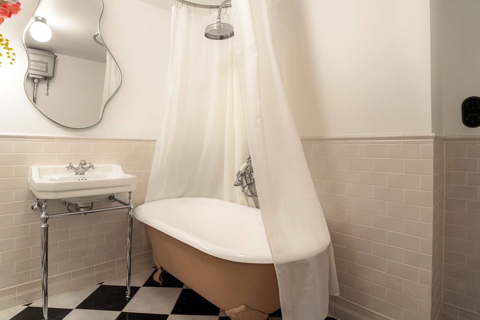 Tidløse detaljer som støpejernsbadekar på løveføtter og marmorgulv i sjakkmønster. Galleribilde