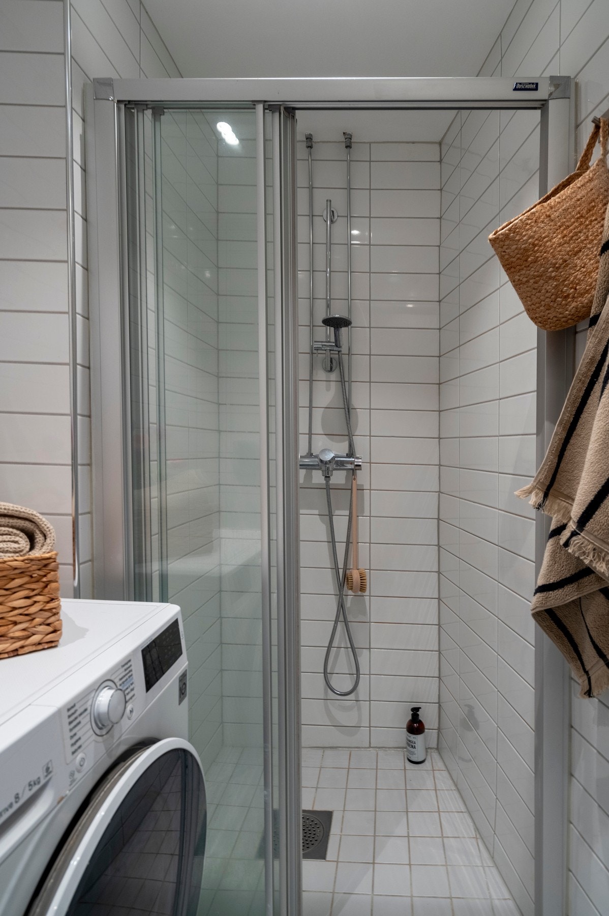 Baderommet har lyse fliser på gulv med gulvvarmee, nye downlights i himlingen og opplegg for vaskemaskin. Galleribilde