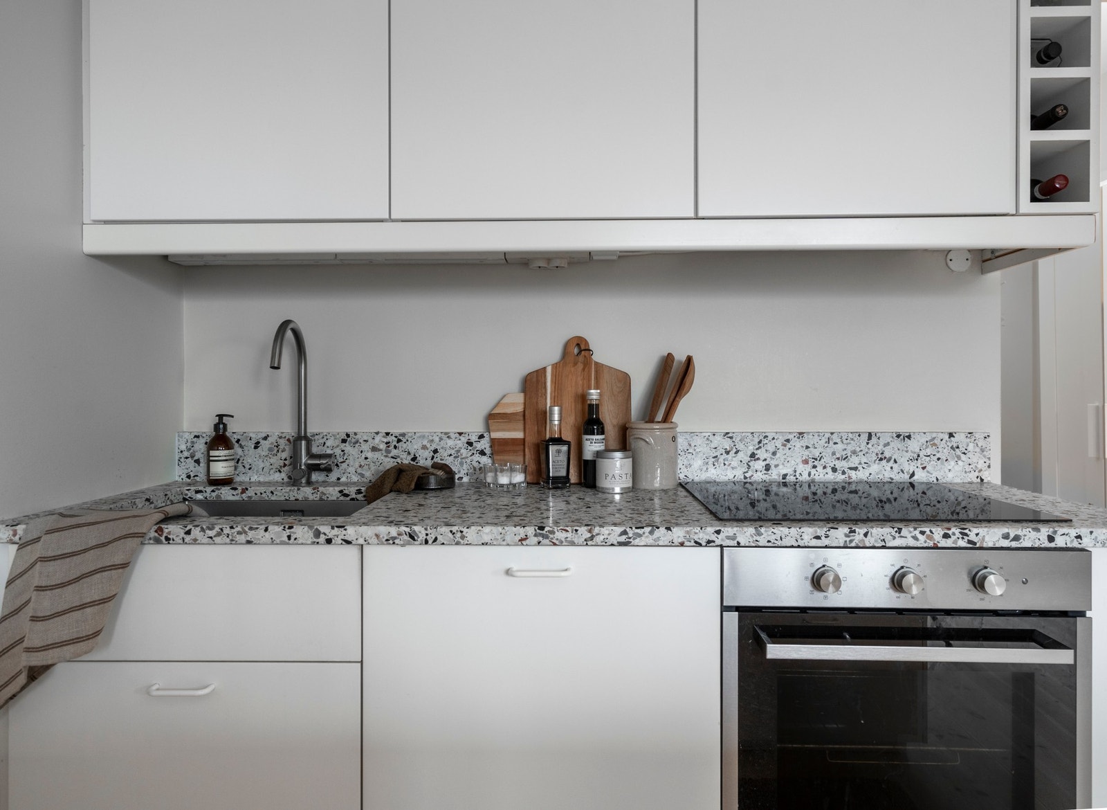 Kjøkkenet har integrerte hvitevarer, plassbygde skap og benkebelysning. Galleribilde