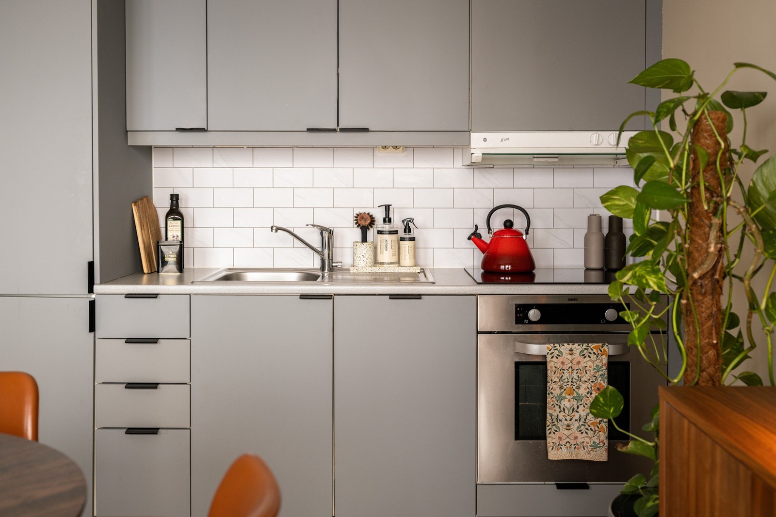 Både fint og praktisk med lyse fliser i benkeryggen og belysning under overskapene. Galleribilde