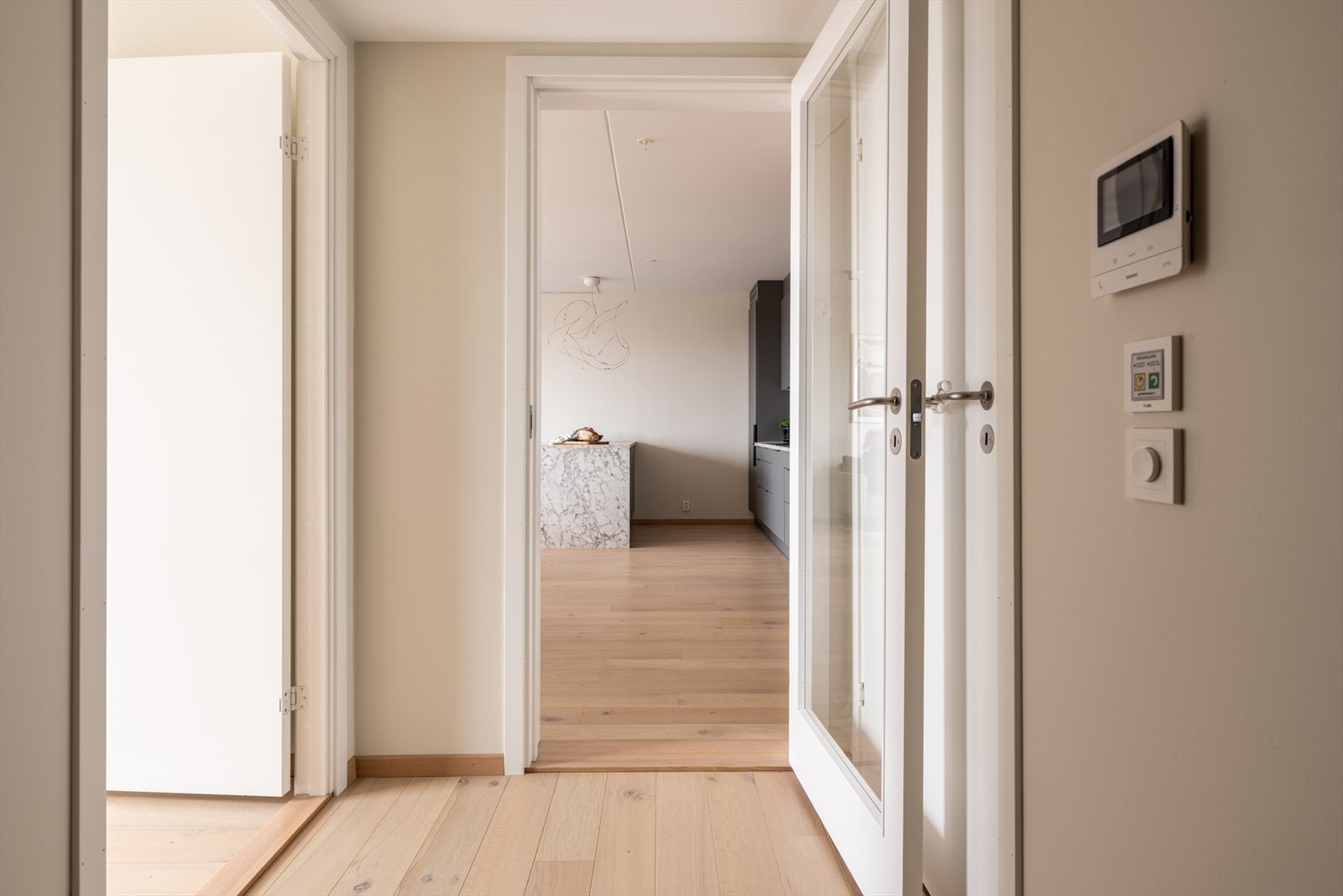 Vi tar turen inn igjen - oppholdsrommet er adskilt fra resten av leiligheten med en stilren glassdør. Galleribilde