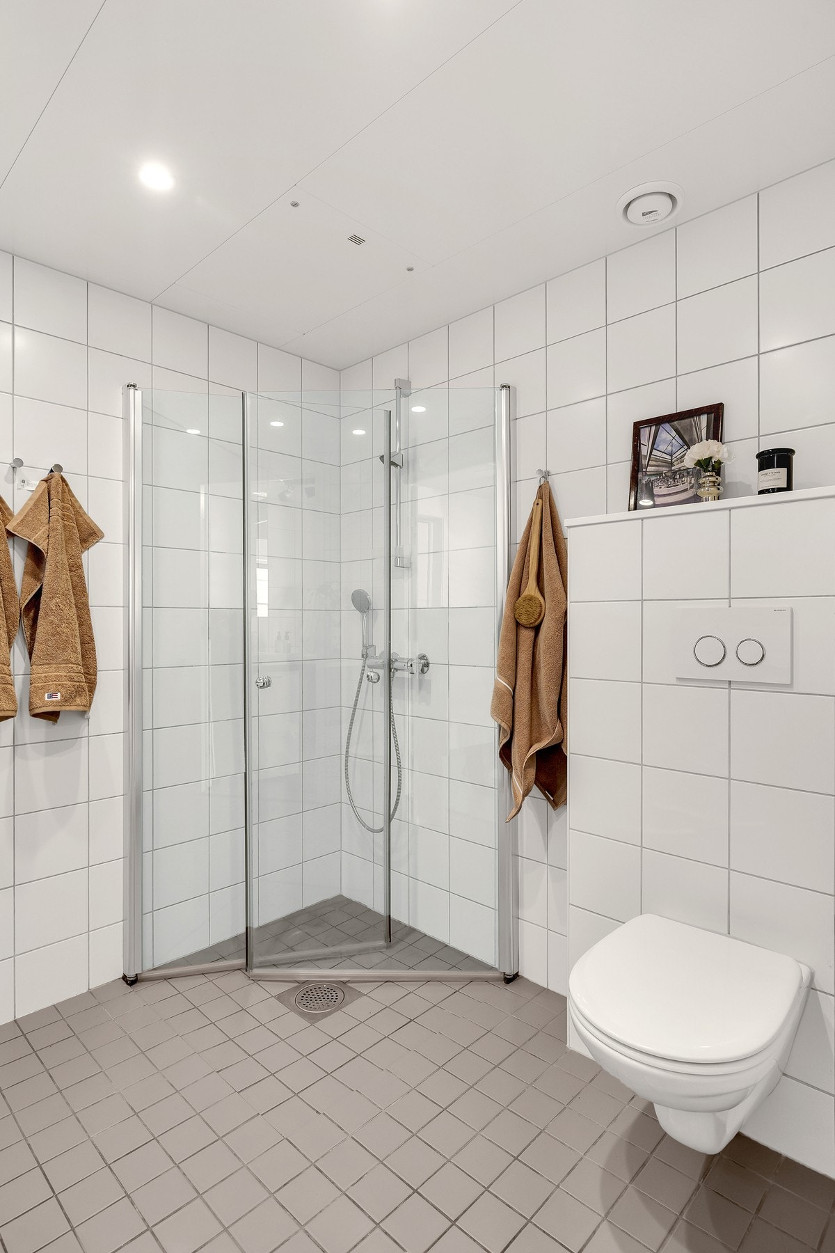 Veggmontert toalett og dusjnisje med innfellbare dører i glass. Galleribilde