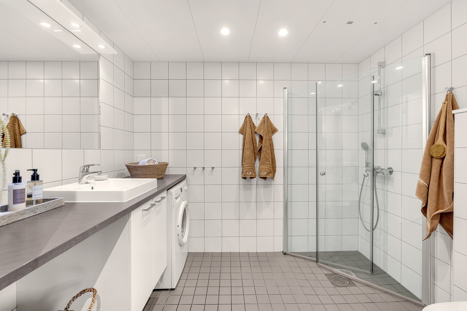 Delikat og pent flislagt bad med slett lys innredning med servant og ettgreps blandebatteri. Galleribilde