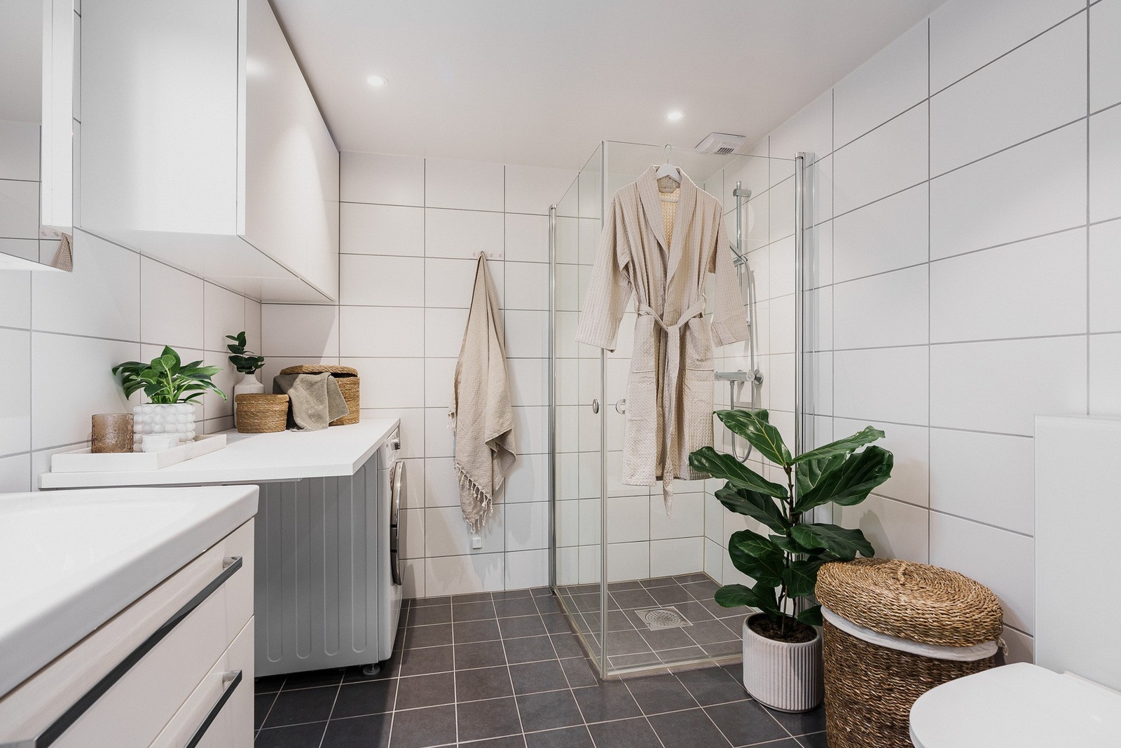 Flislagt bad med vannbåren gulvvarme, vegghengt toalett, og innfellbare dusjdører for optimal plassutnyttelse. Galleribilde