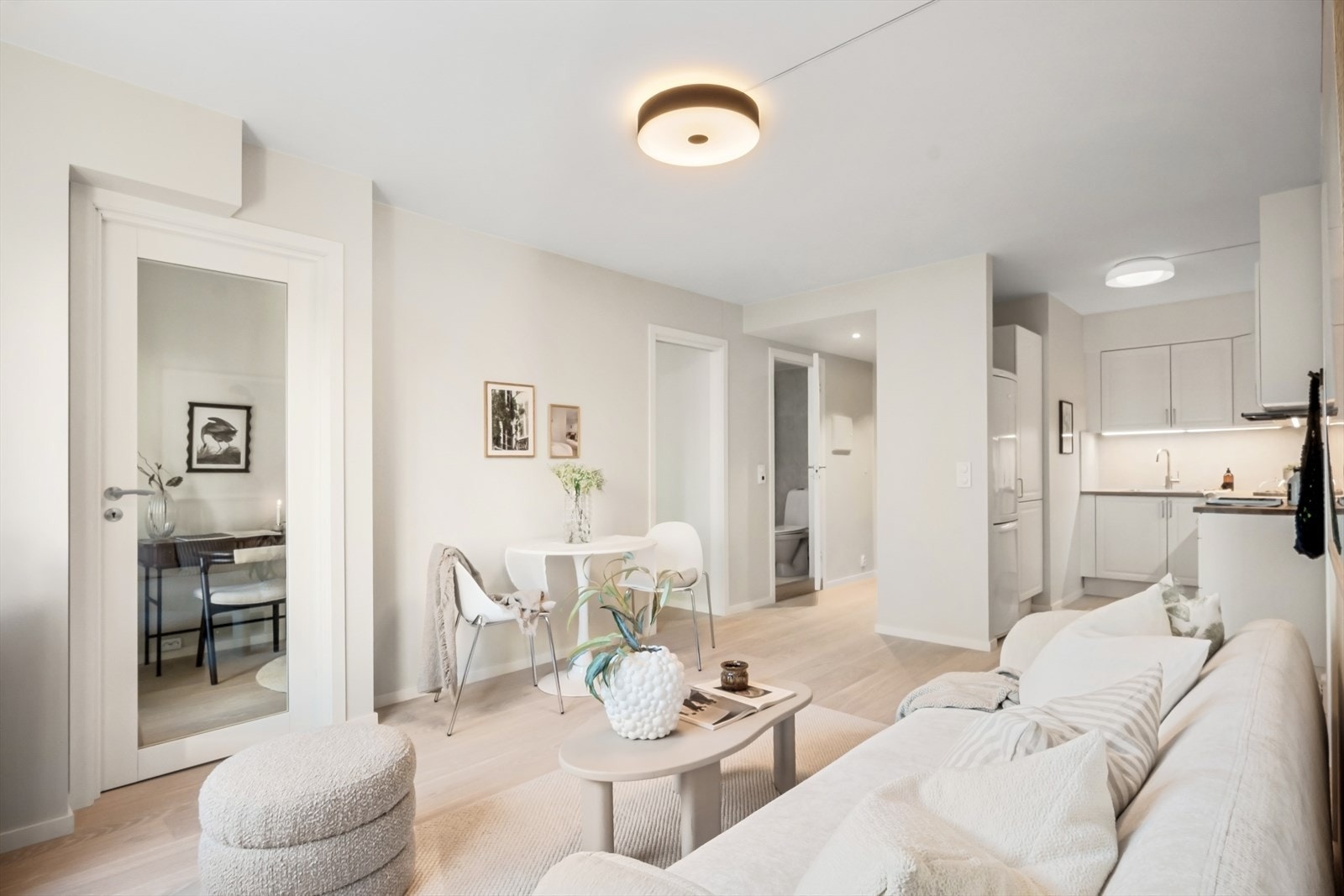 Den ene døren er en flott glassdør som slipper lyset fra vinduene og balkongen inn i hele leiligheten. Galleribilde