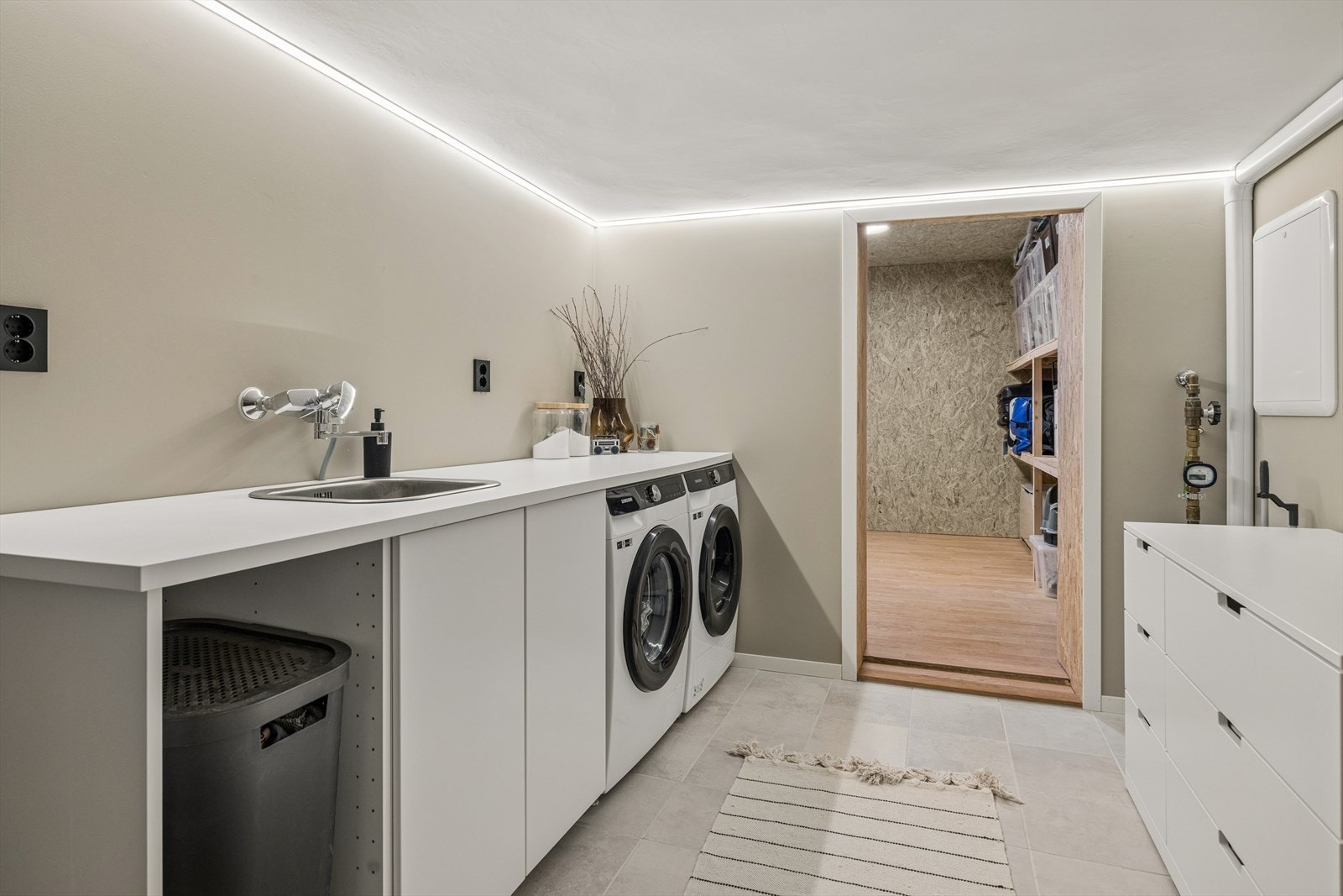 Praktisk og romslig vaskerom med god benkeplass og opplegg for vaskemaskin. Herfra er det tilgang til en av boligens innvendige boder. Galleribilde