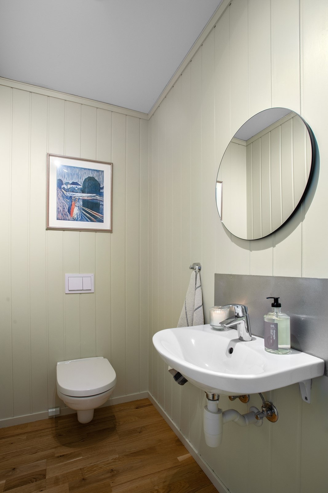 Toalettrom med 3-stavsparkett på gulv. Innredet med vegghengt servant og toalett Galleribilde