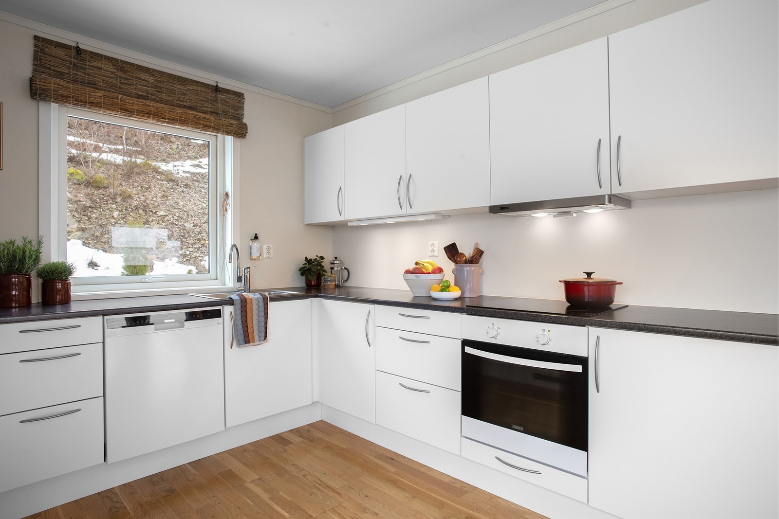 Kjøkken med innredning med slette fronter. Benkeplate med laminert flate og nedfelt oppvaskkum. Galleribilde