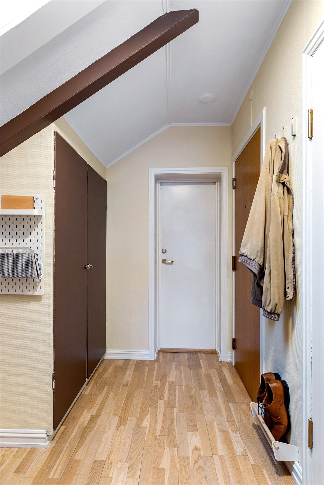 Lys og praktisk entré med god plass til oppbevaring. Smarte garderobeløsninger og en ryddig planløsning gir et innbydende førsteinntrykk. Hvit dør gir direkte utgang til fellesboder. Galleribilde