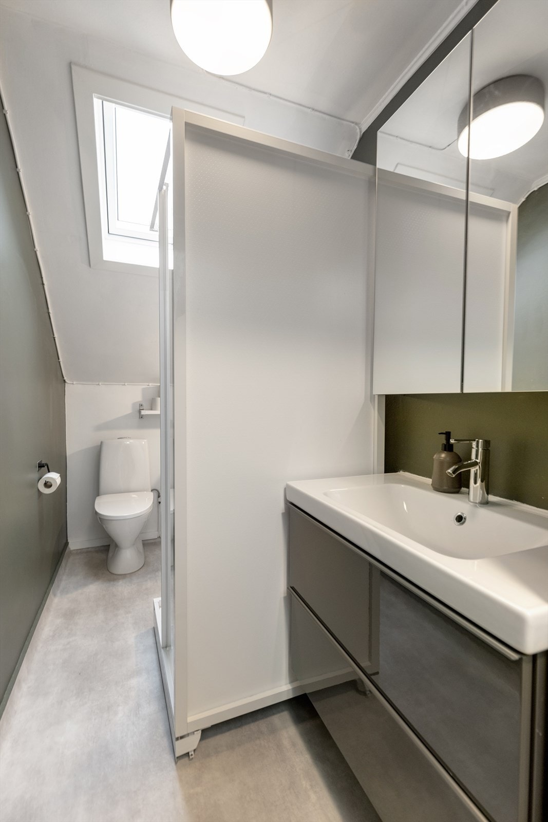 Lyst og funksjonelt bad med takvindu som gir godt dagslys. Praktisk planløsning med dusjkabinett, moderne servantinnredning, toalett og opplegg for vaskemaskin. Galleribilde