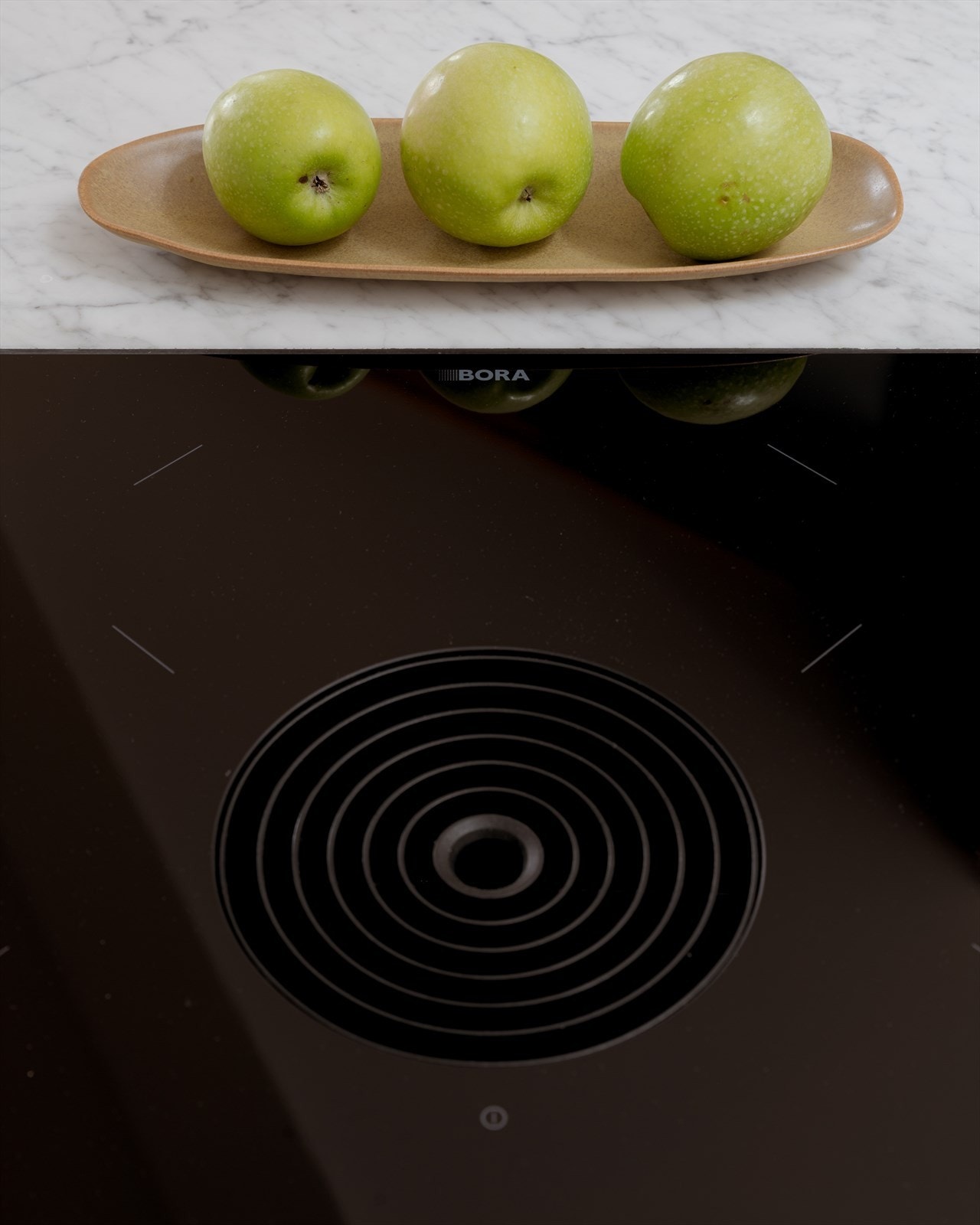 Kjøkkenet har benkeplate av Carrara-marmor med underlimt vask og planlimt Bora koketopp. Galleribilde